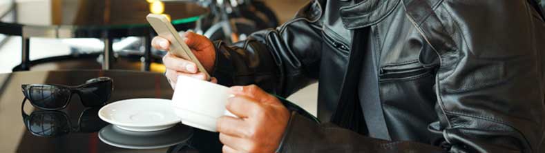 רוכב אופנוע שותה כוס קפה